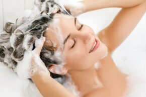 woman washing hair and exfoliating scalp