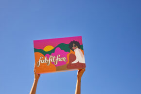 Girl holding Fall FabFitFun box up in air