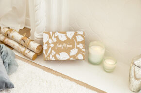 FabFitFun Intro Box on ground with candles and logs