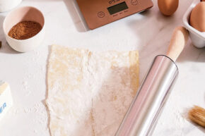 Dough and eggs on kitchen counter with Short Stories Rolling Pin