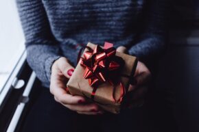 woman holding wrapped present in box