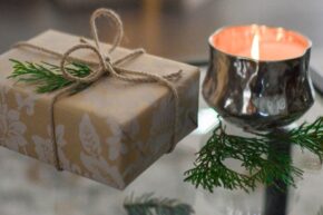 Wrapped holiday gift and candle on a table