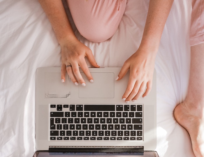 girl online shopping on bed