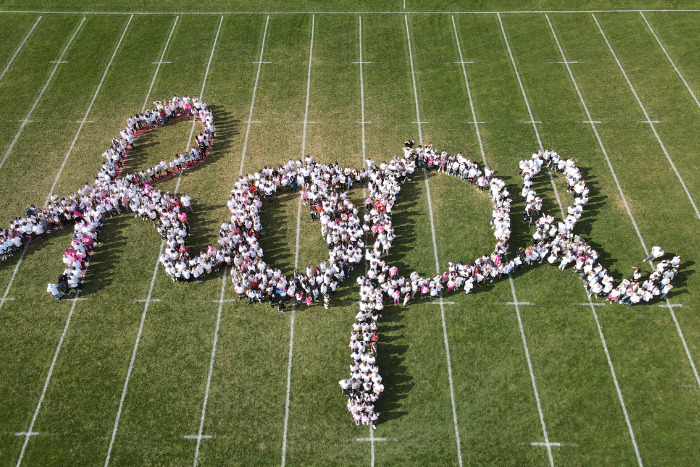 People spelling out "hope" on a field, view from above