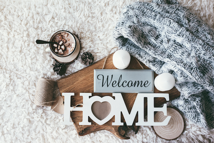 Image says welcome home set in cozy scene with hot chocolate and blanket