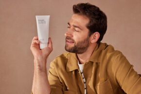 man holding necessaire body lotion to the side facing it