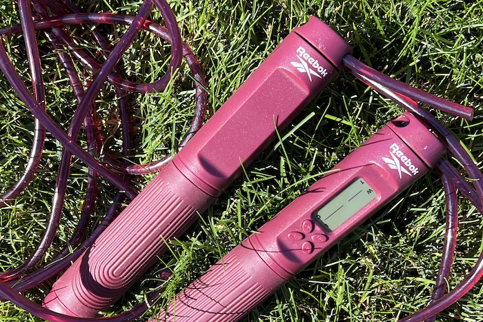 overhead view of the reebok 2-in-1 digital jump rope laying on grass