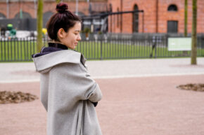 side profile girl smiling in park with top knot bun hairstyle
