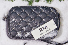 rebecca minkoff bag flatlay image on snow background