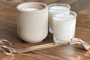 Candle set on wooden table with candle wick trimmer in front